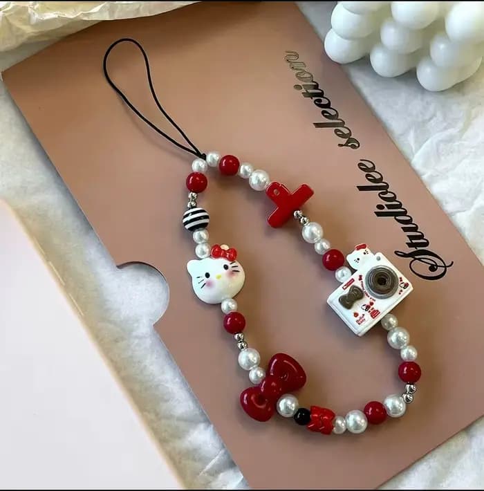 Cordon de téléphone Kawaii Hello Kitty avec nœud et perles pour appareil photo, accessoire de téléphone tendance pour fille 2026
